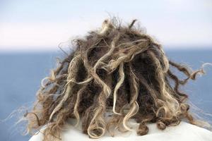 rasta Mens haar- in de wind op zoek Bij de oceaan foto