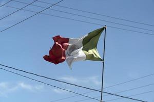 gescheurd Mexicaans vlag golvend tussen draden foto