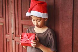 jongen met geschenkdoos op eerste kerstdag foto