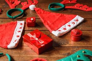 rode geschenkdoos en kerstmuts op houten achtergrond foto