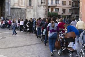 Murcia, Spanje - maart 25 2019 - moeder en zonen aan het wachten voor zegen van maagd de la Fuensanta foto