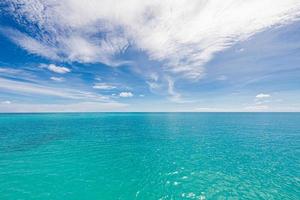 turkoois water en blauw lucht net zo achtergrond afbeelding. caraïben zee panorama, Maldiven eilanden, Hawaii, Thailand oceaan wateren, turkoois tropisch paradijs eiland. panorama van zee golven. vredig natuur foto