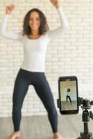latijnse vrouw heeft haar dansvideo gemaakt met een smartphonecamera. om video te delen met een toepassing voor sociale media. foto
