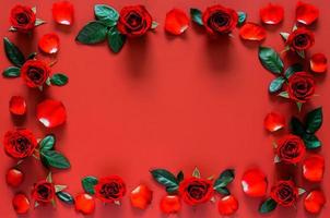 valentijnsdag achtergrond met rozen, bloemblaadjes en bladeren Aan rood achtergrond. foto