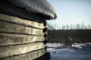 winter in Rusland. sneeuw Aan dak van hut. oud huis gemaakt van hout. foto