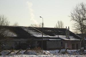 industrieel gebouw in winter. dak in sneeuw. visie van gevogelte boerderij. foto