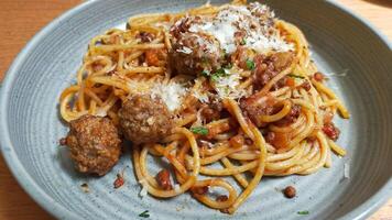 dichtbij omhoog foto van spaghetti en gehaktballen dienen Bij de bord.