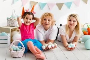 gelukkig familie met Pasen eieren. gelukkig kleintje meisje en grootmoeder met Pasen eieren foto