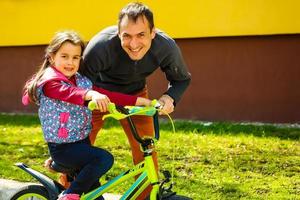 gelukkig vader onderwijs zijn weinig dochter naar rijden een fiets. kind aan het leren naar rijden een fiets. familie activiteiten Bij zomer. foto