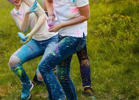 vrolijk jong multi-etnisch vrienden met kleurrijk verf Aan kleren en lichamen hebben pret samen Bij holi festival foto