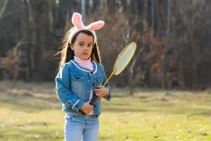 weinig meisje hebben pret Aan Pasen. kinderen in konijn oren. kleuter kind spelen buitenshuis. foto