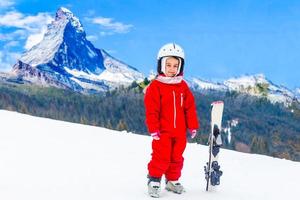 gelukkig weinig meisje skiën bergafwaarts foto