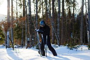 volwassen mannetje skiër Aan besneeuwd berg foto