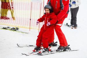 instructeur shows weinig meisje en sommige opdrachten Aan skis foto
