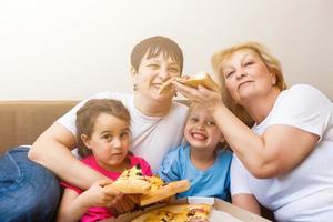 familie aan het eten pizza samen Bij huis foto