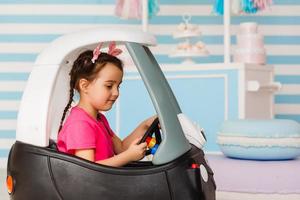 weinig meisje in de auto een kinderen partij in versierd kamer foto