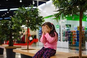 aanbiddelijk weinig meisje is huilen in de winkelcentrum foto