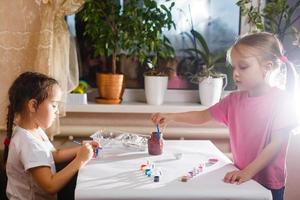 twee schattig weinig zussen tekening met kleurrijk Bij een kinderopvang creatief kinderen schilderij samen foto