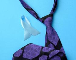 zijde Purper Mannen stropdas en blauw lint gevouwen in een lus Aan blauw achtergrond foto