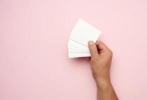 mannetje hand- Holding een stack van blanco wit bedrijf kaarten foto