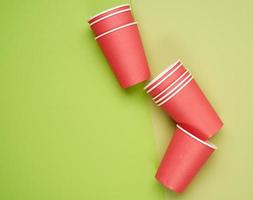 stack van rood papier beschikbaar cups Aan een blauw achtergrond, vlak leggen, concept milieuvriendelijk foto