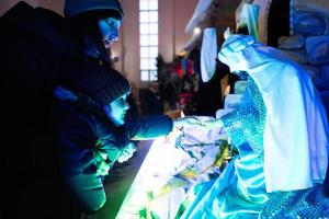 moeder met dochter op zoek Bij Kerstmis geboorte wieg tafereel in kerk. foto