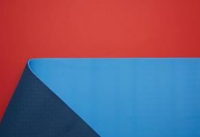 neopreen blauw gedraaid mat leugens Aan een rood achtergrond, sport- uitrusting foto