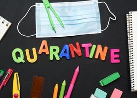 opschrift quarantaine van veelkleurig plastic brieven en school- benodigdheden Aan zwart krijt bord foto