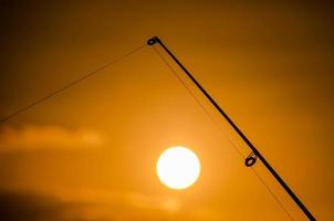visvangst haspel over- de zonsondergang foto