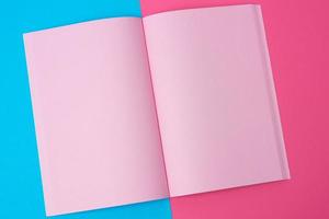 Open notitieboekje met blanco roze Pagina's Aan een blauw achtergrond foto