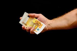 hand- Holding contant geld Aan zwart achtergrond foto