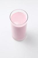aardbei gearomatiseerd roze melk in een glas Aan een wit achtergrond. foto