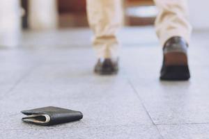 jong Mens had verloren leer portemonnee met geld Aan de straat. detailopname van portemonnee aan het liegen Aan de weg beton trottoir in gedurende de reis naar reizen. met filter tonen retro wijnoogst warm effect. foto