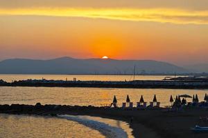 zonsondergang over- zee met uitgestorven strand in Italië foto