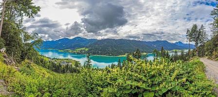 panoramisch visie over- turkoois meer weissensee in oostenrijks provincie Karinthië gedurende dag foto