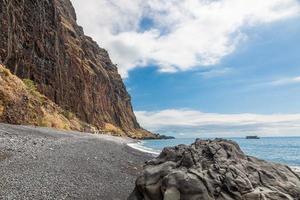 visie over- de steenachtig strand van fajas de cabo girao Aan de portugees eiland van Madeira in zomer foto