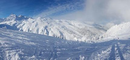 panoramisch visie over- besneeuwd ski toevlucht in oostenrijks Alpen gedurende dag foto