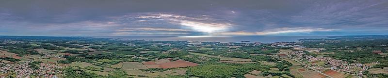 dar panorama over- Istrisch adriatisch kust in de buurt porec genomen van hoog hoogte gedurende dag met bewolkt lucht en indrukwekkend zon stralen foto