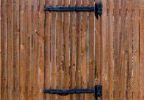 structuur houten hek met een houten deur Aan ijzer scharnieren foto