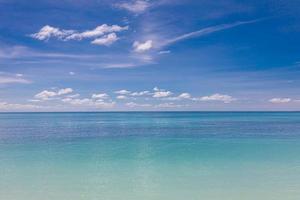 turkoois water en blauw lucht net zo achtergrond afbeelding. caraïben zee panorama, Maldiven eilanden, Hawaii, Thailand oceaan wateren, turkoois tropisch paradijs eiland. panorama van zee golven. vredig natuur foto