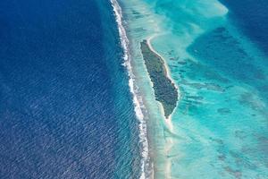 antenne visie van Maldiven toevlucht, luxe reizen bestemming. vogelstand oog visie van diep blauw zee, koraal riet, tropisch eiland. verbazingwekkend natuur visie, dar antenne landschap foto