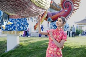 gelukkig Chinese nieuw jaar. Aziatisch vrouw vervelend traditioneel cheongsam qipao jurk. foto