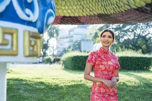 gelukkig Chinese nieuw jaar. Aziatisch vrouw vervelend traditioneel cheongsam qipao jurk. foto