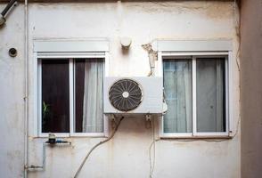 lucht conditioner buitenshuis eenheid geïnstalleerd tussen twee ramen foto