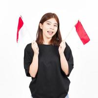 glimlachen en Holding Indonesisch vlag van mooi Aziatisch vrouw geïsoleerd Aan wit achtergrond foto
