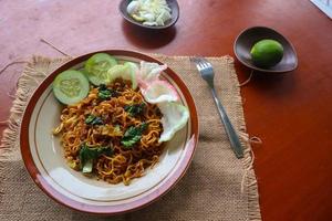 mie tek tek of gebakken noodle gemaakt met ei noedels met kip, kool, mosterd groenen, gehaktballen, door elkaar gegooid eieren. Indonesisch voedsel foto