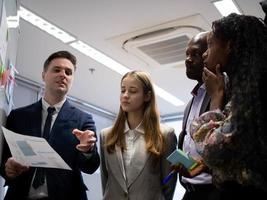 zakenman zakenvrouw afrikaans zwart Kaukasisch persoon groep samenspel collega praten spreken discussie converseren werk baan bezetting carrière mannetje vrouw op zoek leraar studie onderwijs tabel bord foto