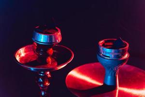 hookah schaal, shisha en kolen detailopname Aan een zwart achtergrond met gekleurde verlichting foto