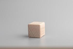 gemakkelijk leeg houten Dobbelsteen, een blanco kubussen gemaakt van hout met een centraal element, grijs achtergrond. kopiëren ruimte, logo ruimte in de midden. foto