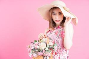 foto van jong Aziatisch meisje vervelend bloem jurk Aan roze achtergrond